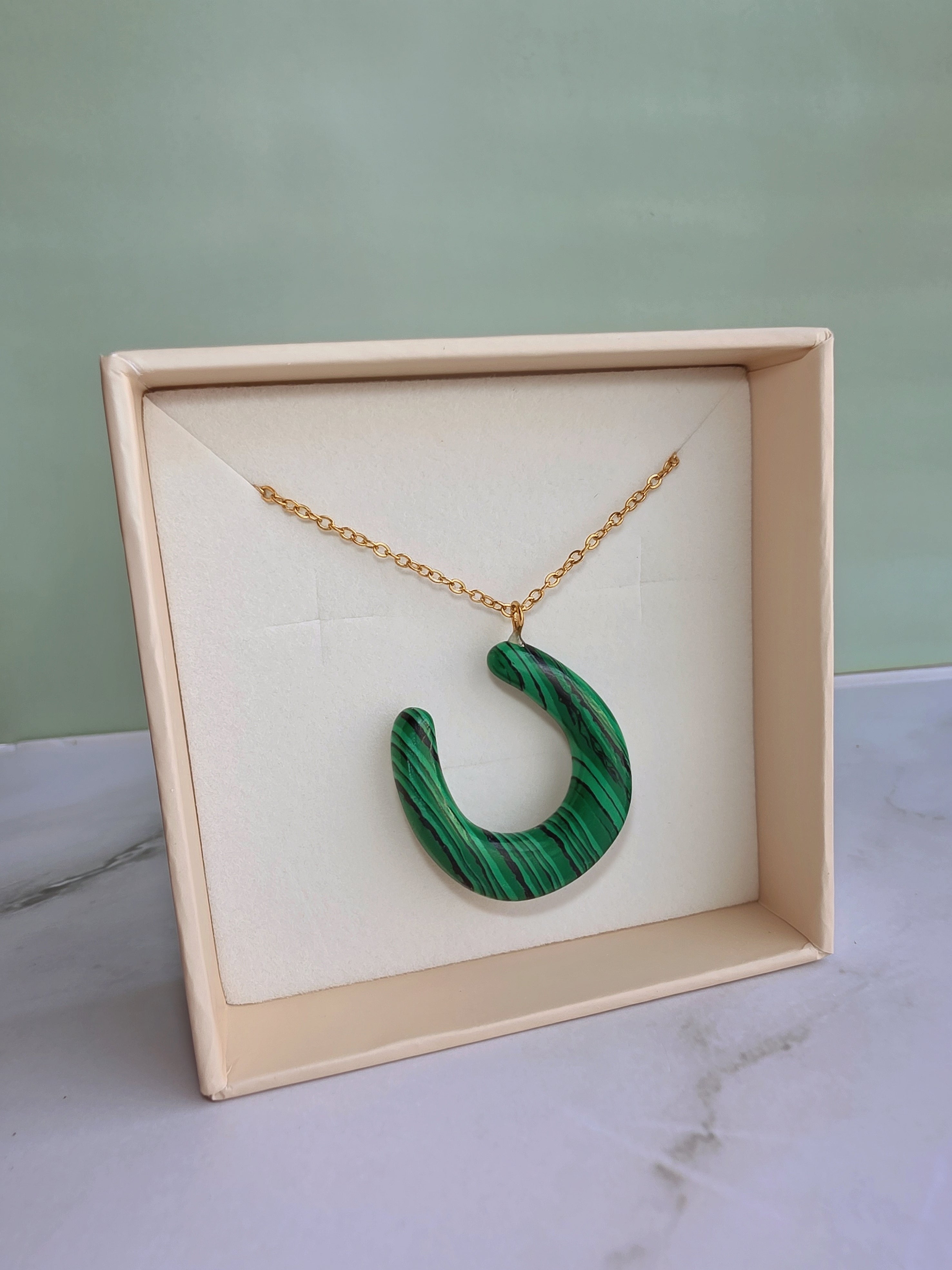 Elegant lucky horseshoe necklace with a natural malachite pendant.
