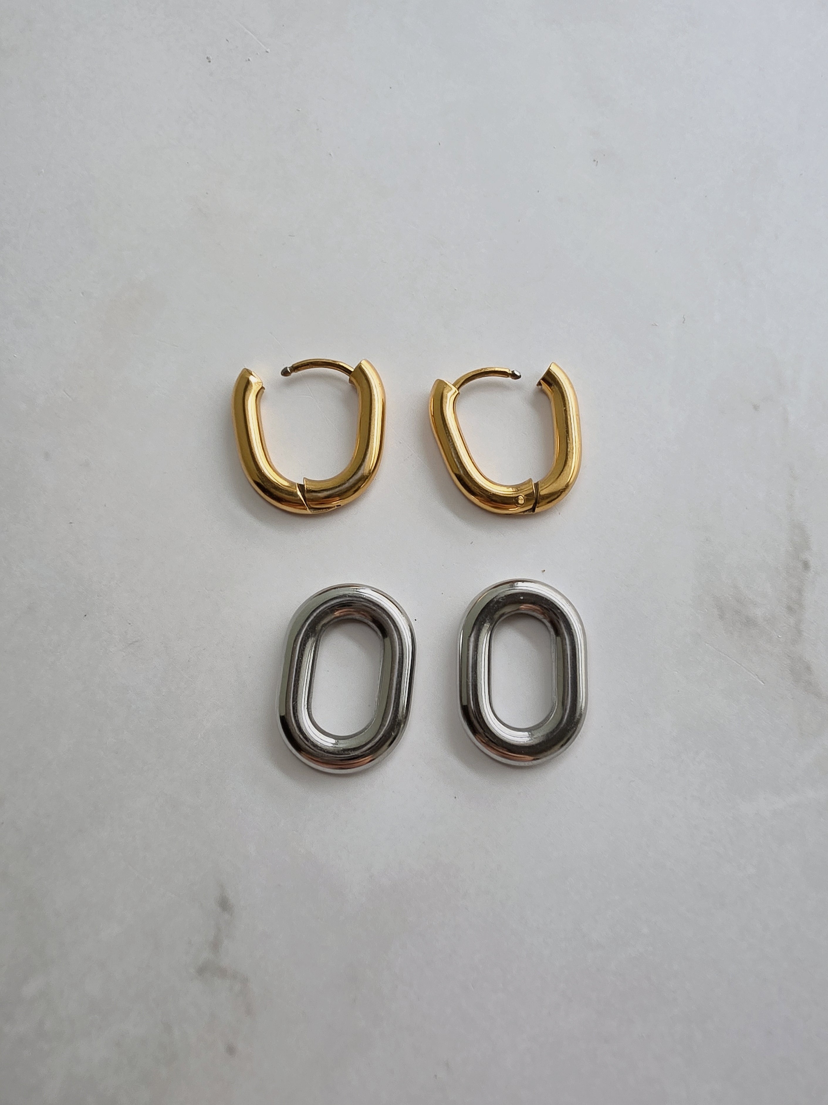Two-tone huggie hoop earrings with an elegant modern design.