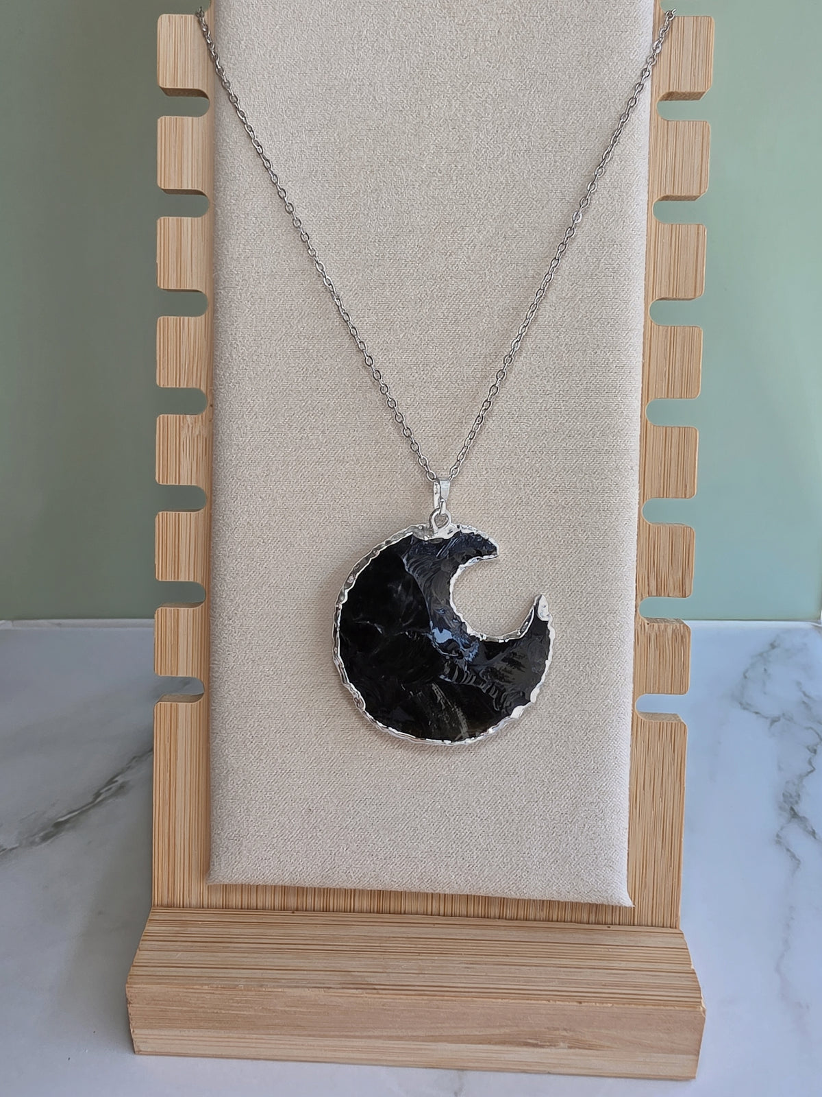 Celestial crystal necklace with a crescent moon-shaped Obsidian pendant.