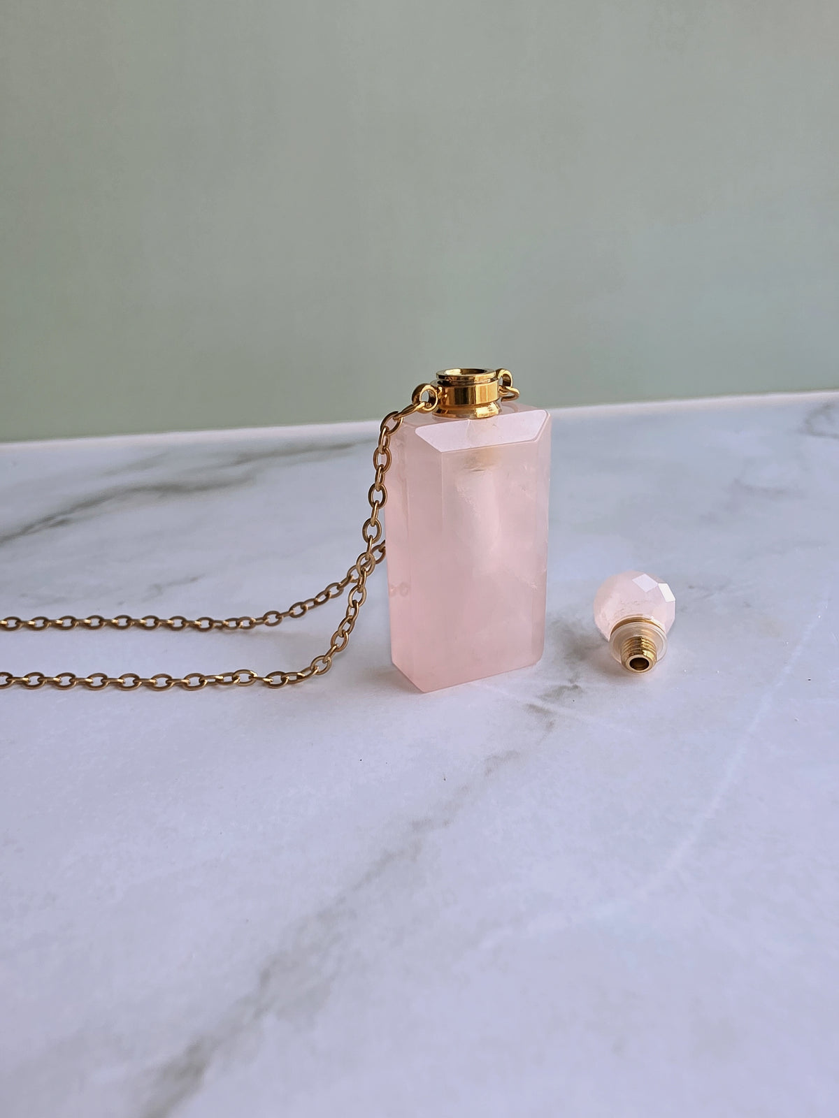 Rose Quartz perfume bottle necklace with a crystal stopper.