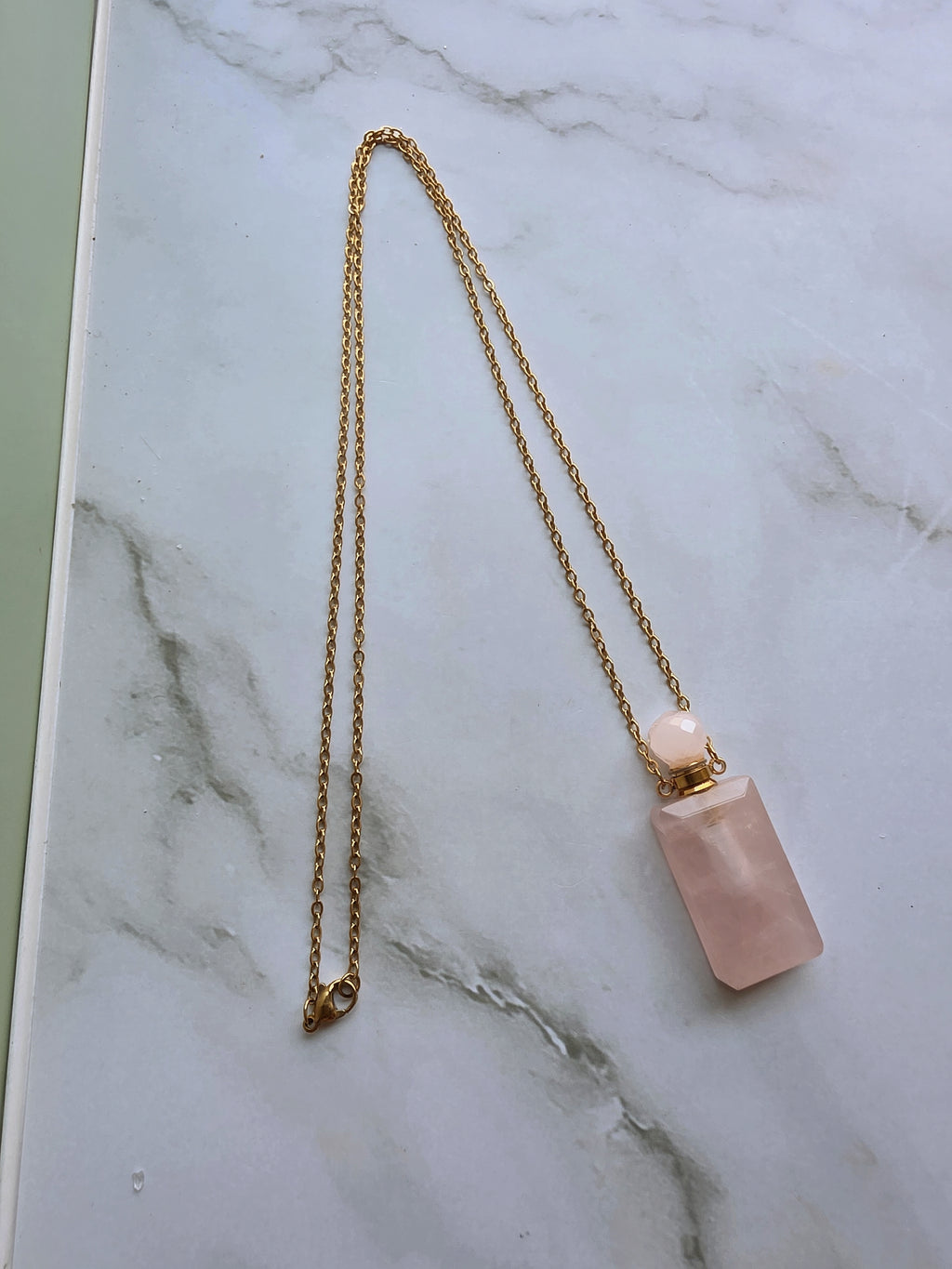 Rose Quartz perfume bottle necklace with a crystal stopper.