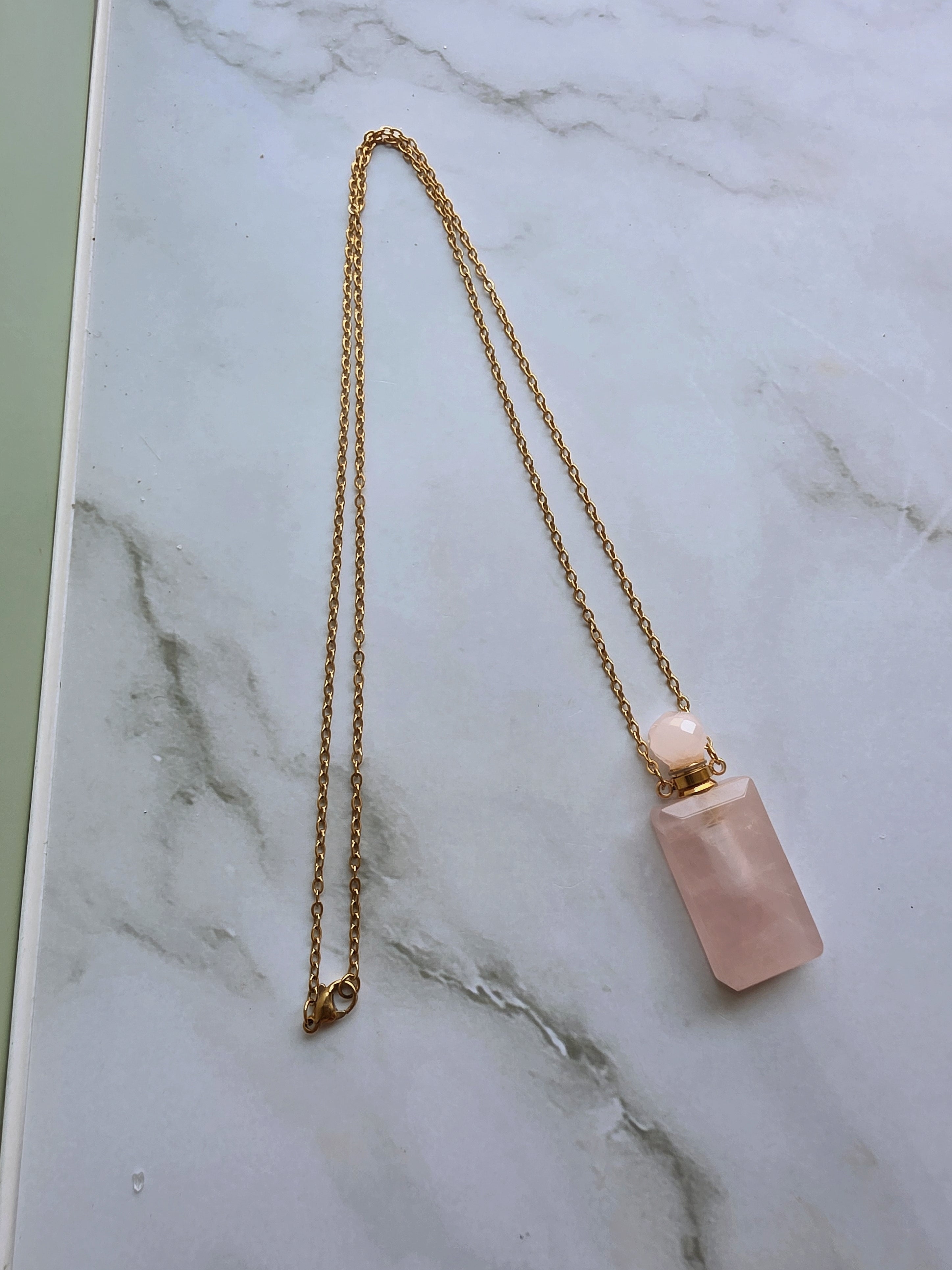 Rose Quartz perfume bottle necklace with a crystal stopper.