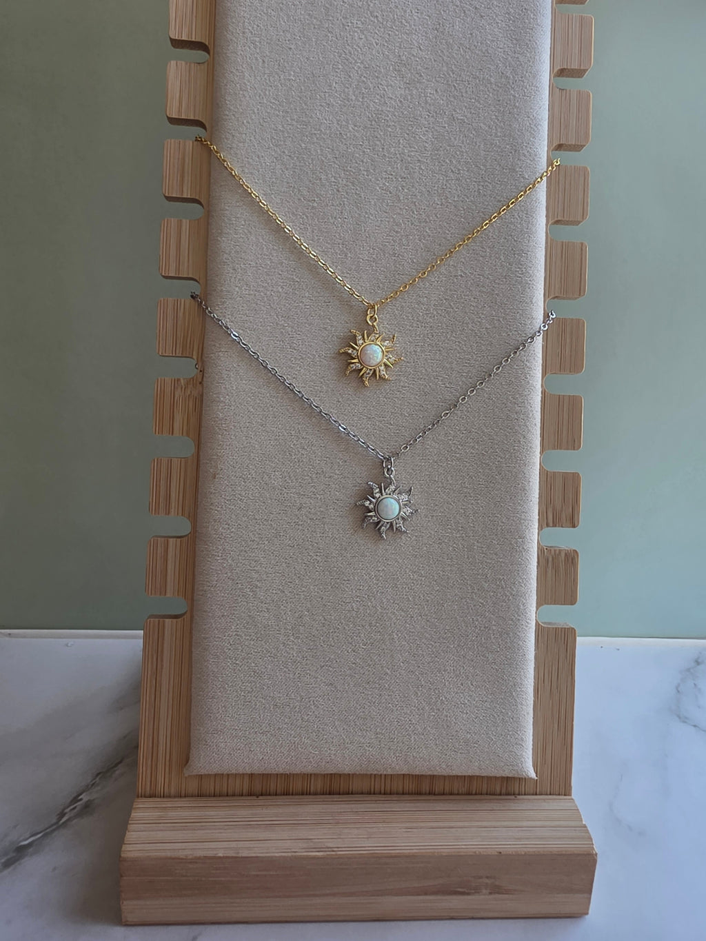 Sun pendant necklace featuring a luminous opal centerpiece.