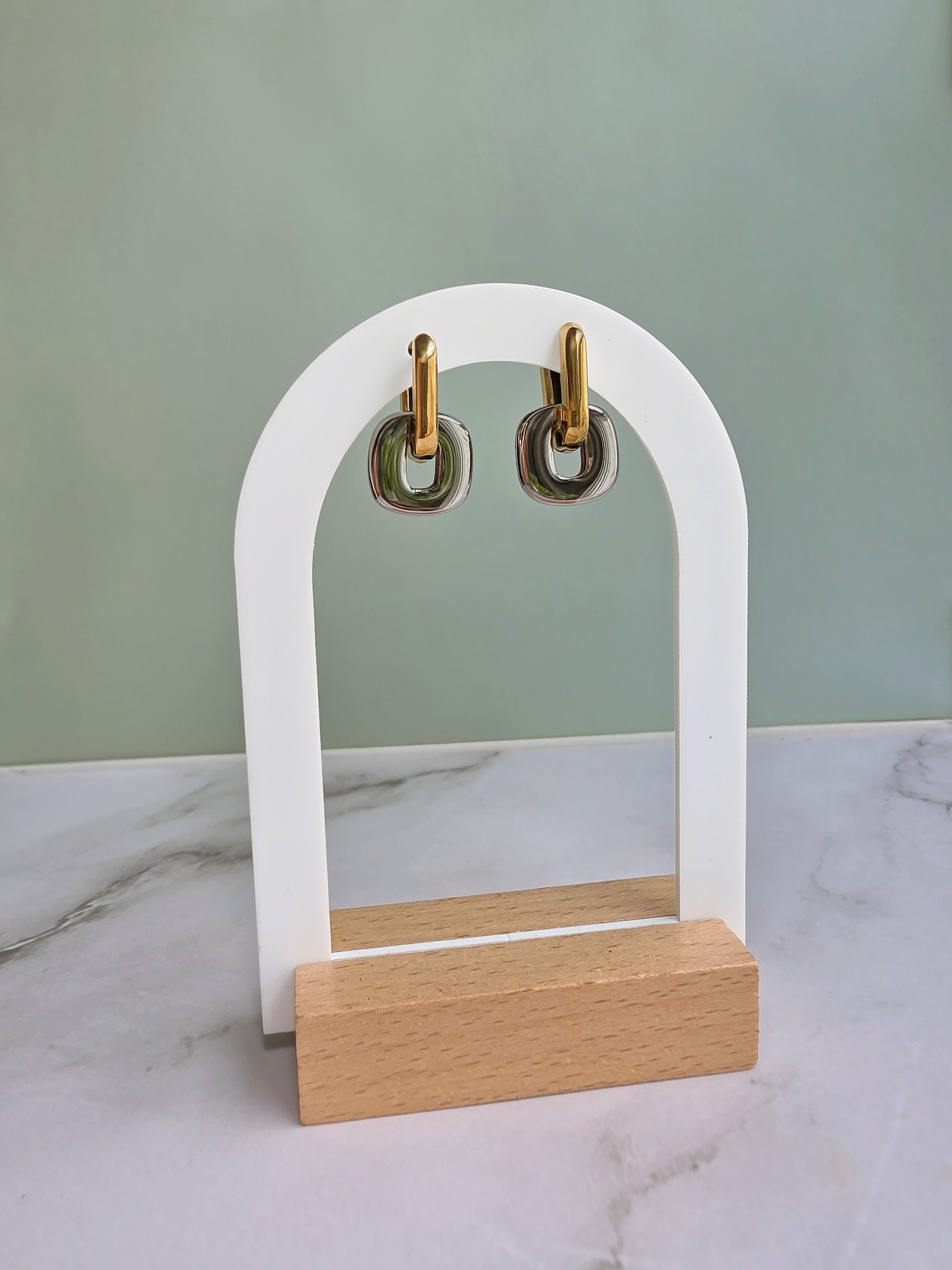 Non tarnish mixed metal earrings crafted from 18K gold-plated and silver stainless steel with a modern two-tone huggie hoop design.