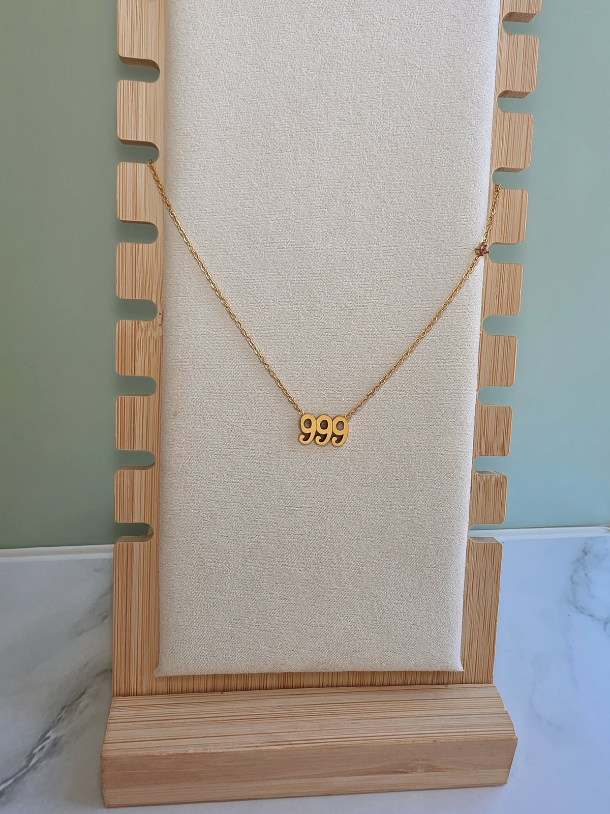 Dainty gold necklace with symbolic angel number design.