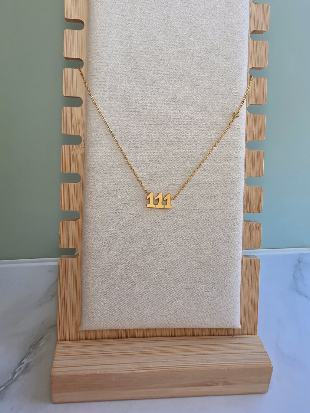 Minimalist number necklace with 111 pendant on a delicate gold chain.