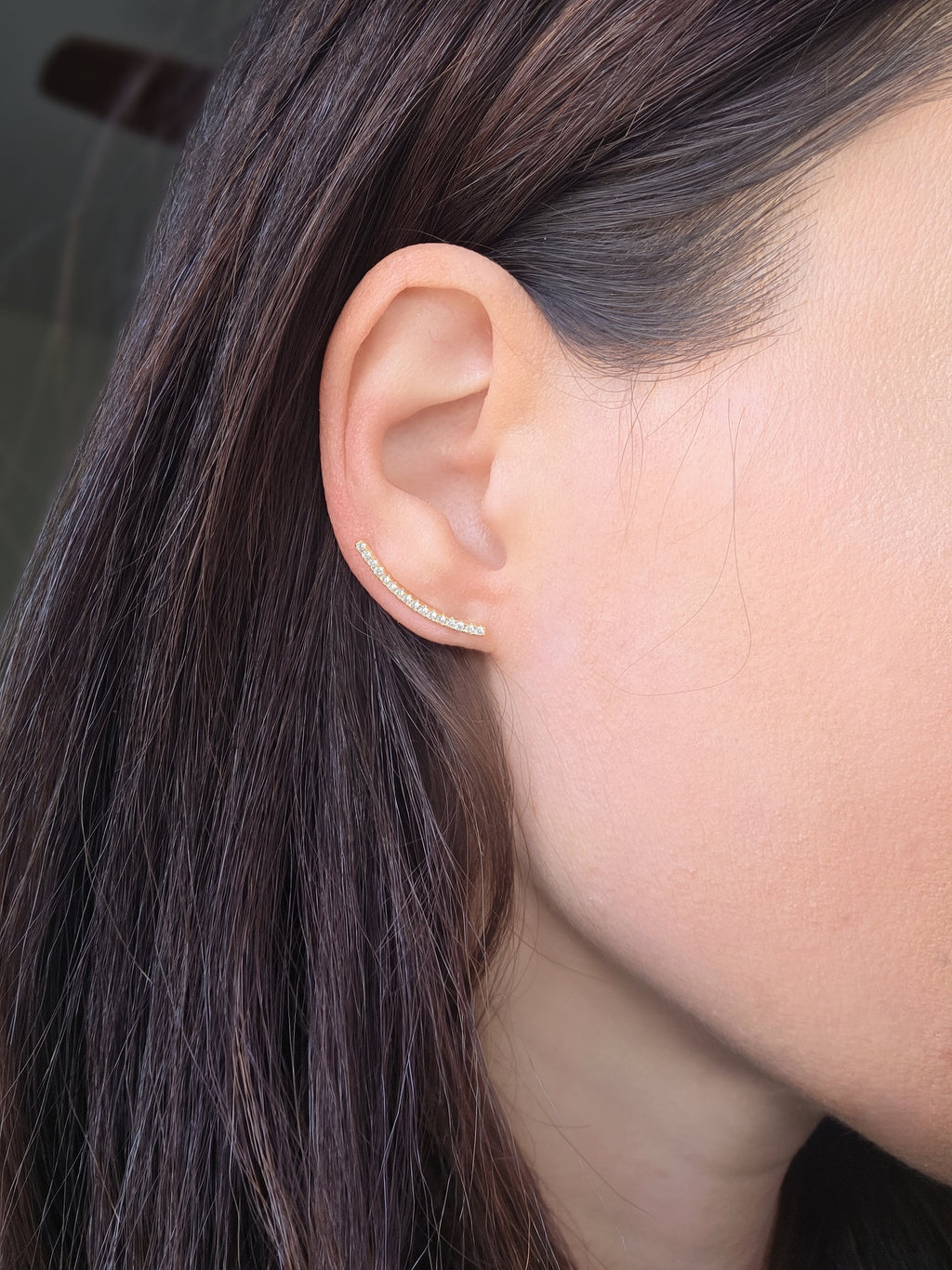 Gold ear climber earrings featuring cubic zirconia crystals.