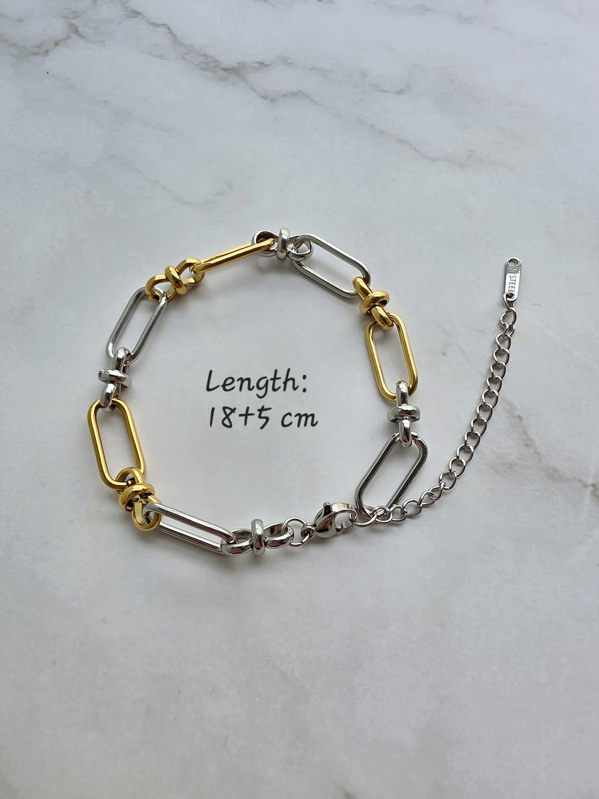 Gold and silver chain bracelet with bold paperclip links.