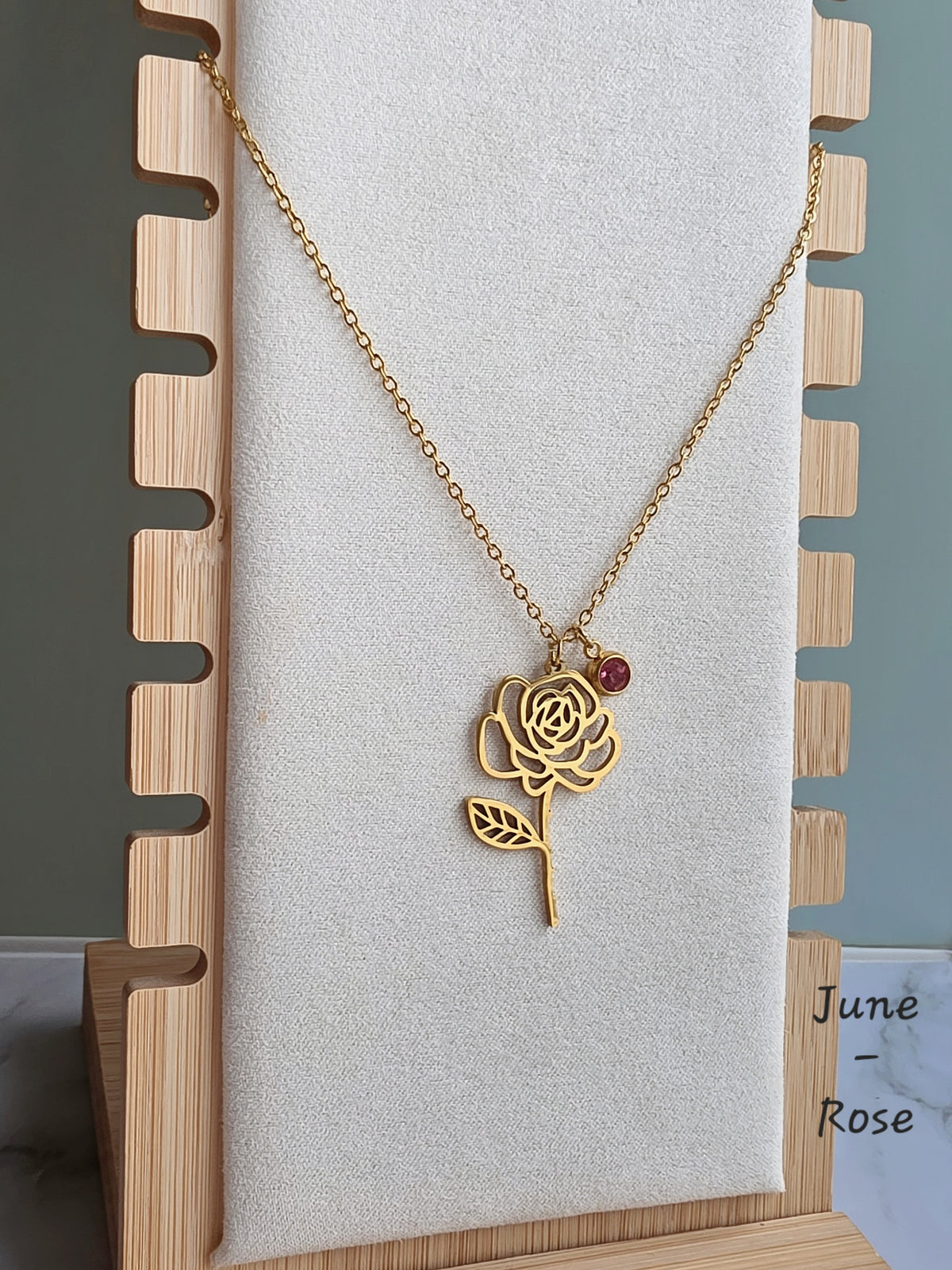 Elegant birth month necklace with engraved flower charm and matching birthstone.