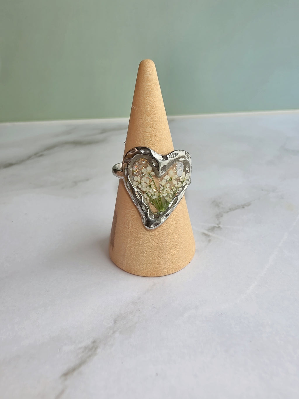 Nature-inspired adjustable heart ring with real pressed flowers.