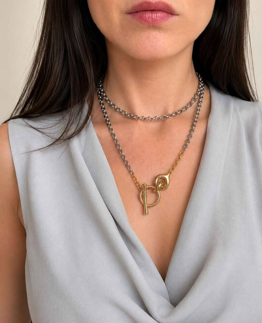 Bold mixed metal statement necklace with polished gold and silver finishes.