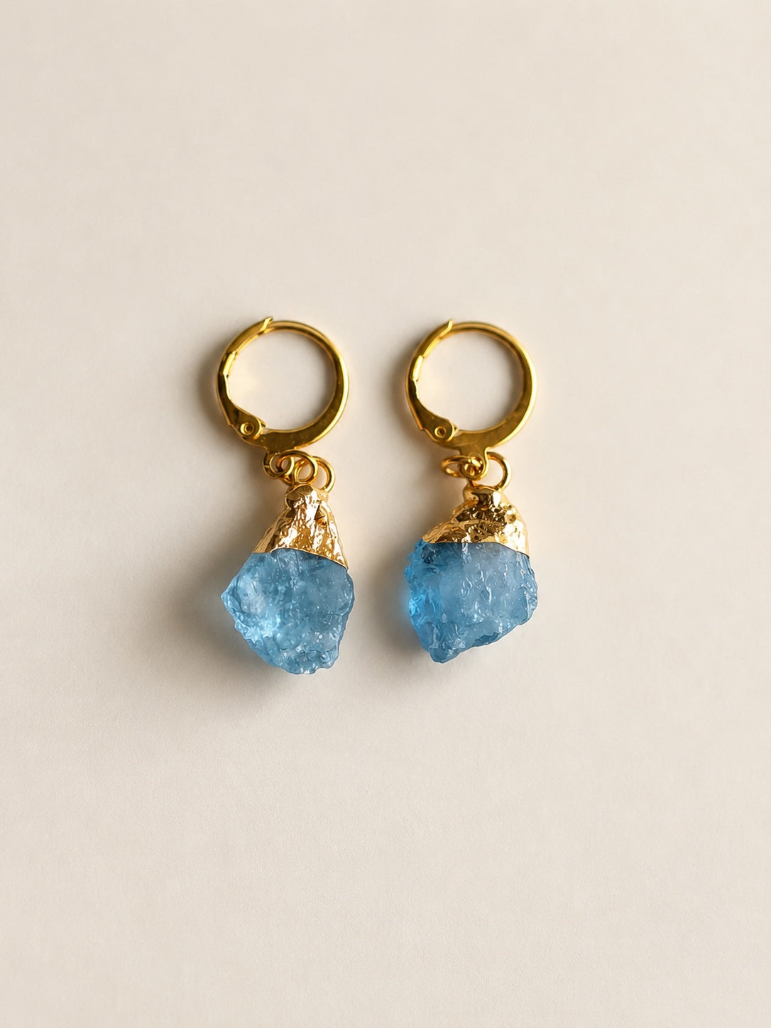 Raw aquamarine hoop earrings in 18K gold plating with natural crystal gemstones.