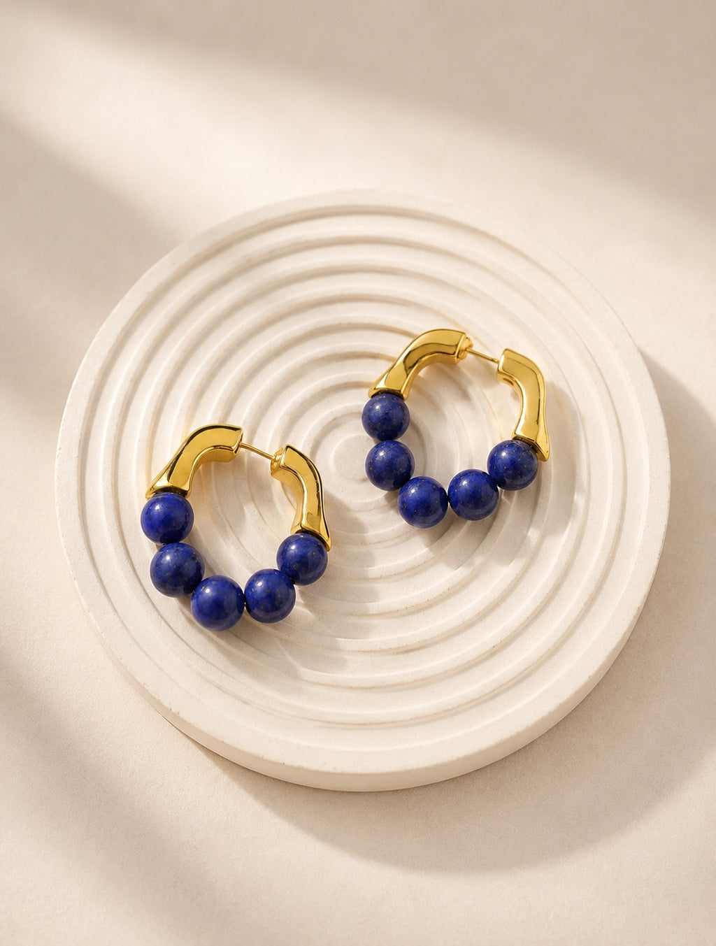 Vintage lapis lazuli hoop earrings with natural blue gemstones and 18K gold plating.