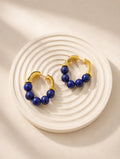 Vintage lapis lazuli hoop earrings with natural blue gemstones and 18K gold plating.