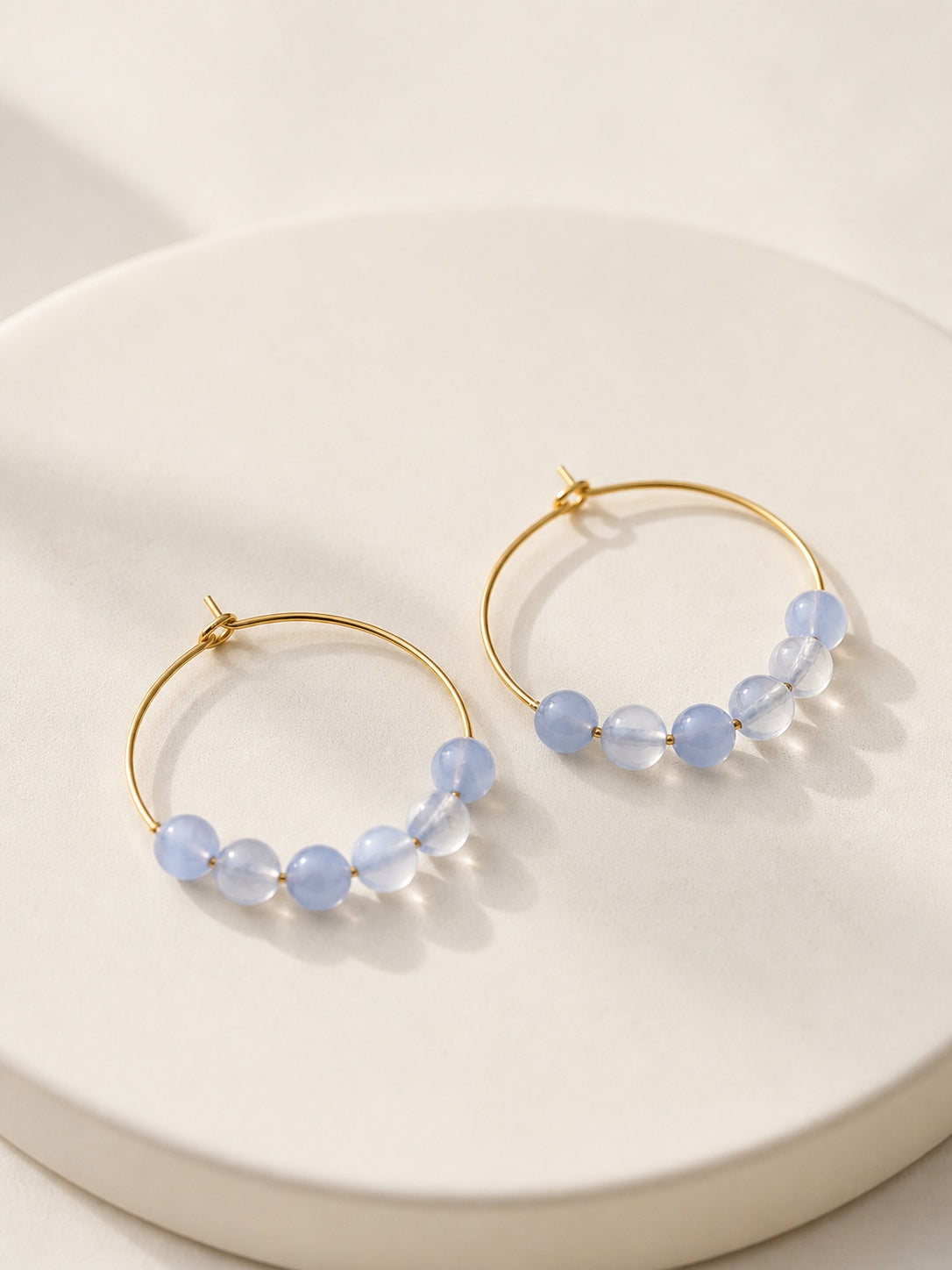 March birthstone hoop earrings featuring polished aquamarine beads and gold hoops.