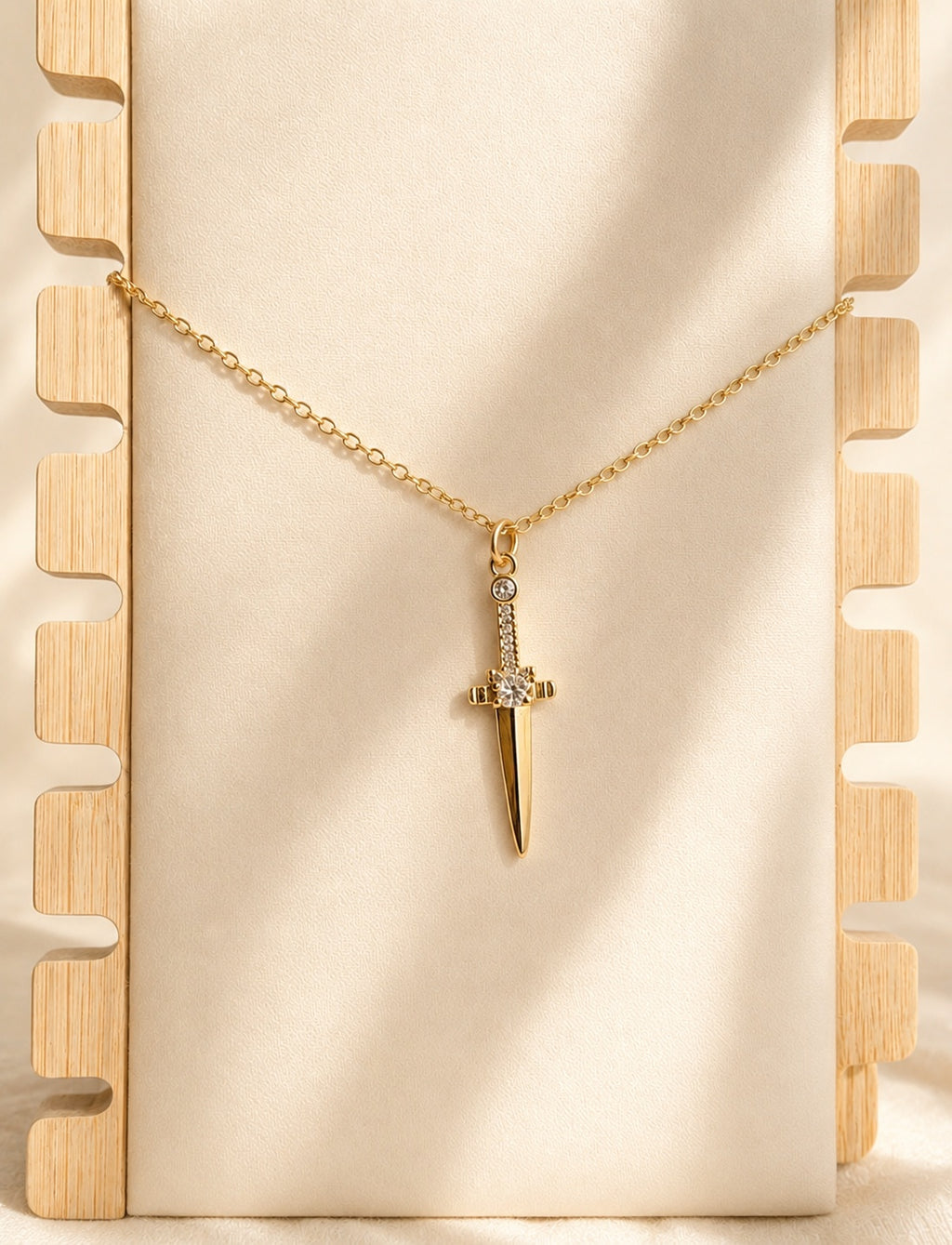 Sword dagger pendant necklace with 14K gold plating and sparkling CZ accents.