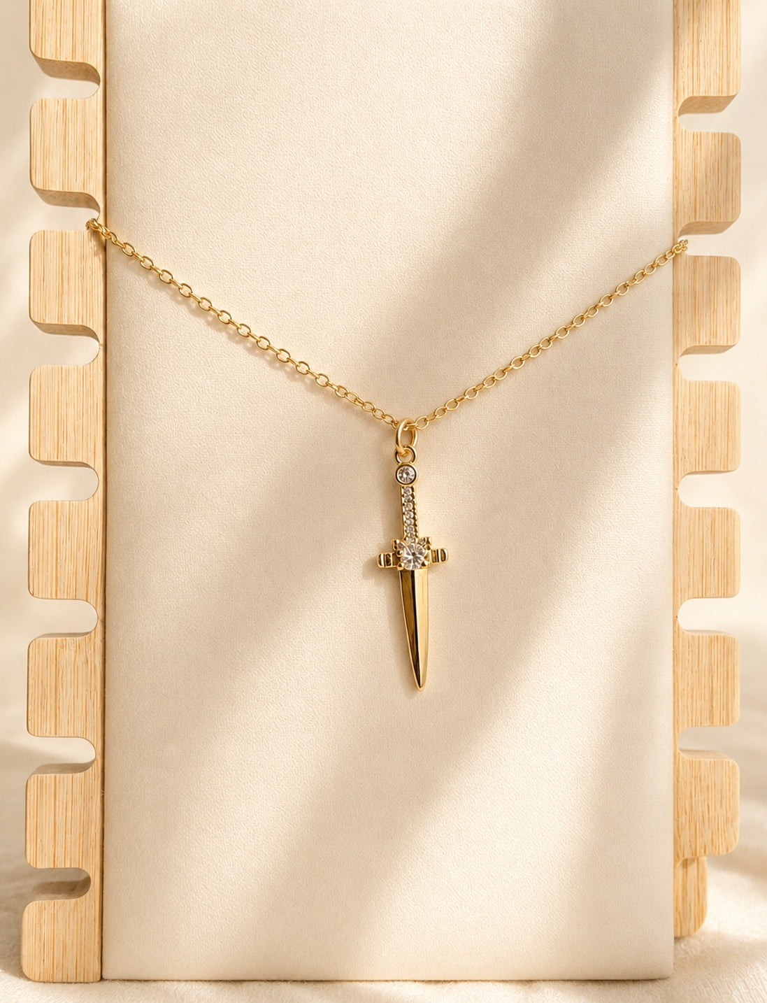 Sword dagger pendant necklace with 14K gold plating and sparkling CZ accents.