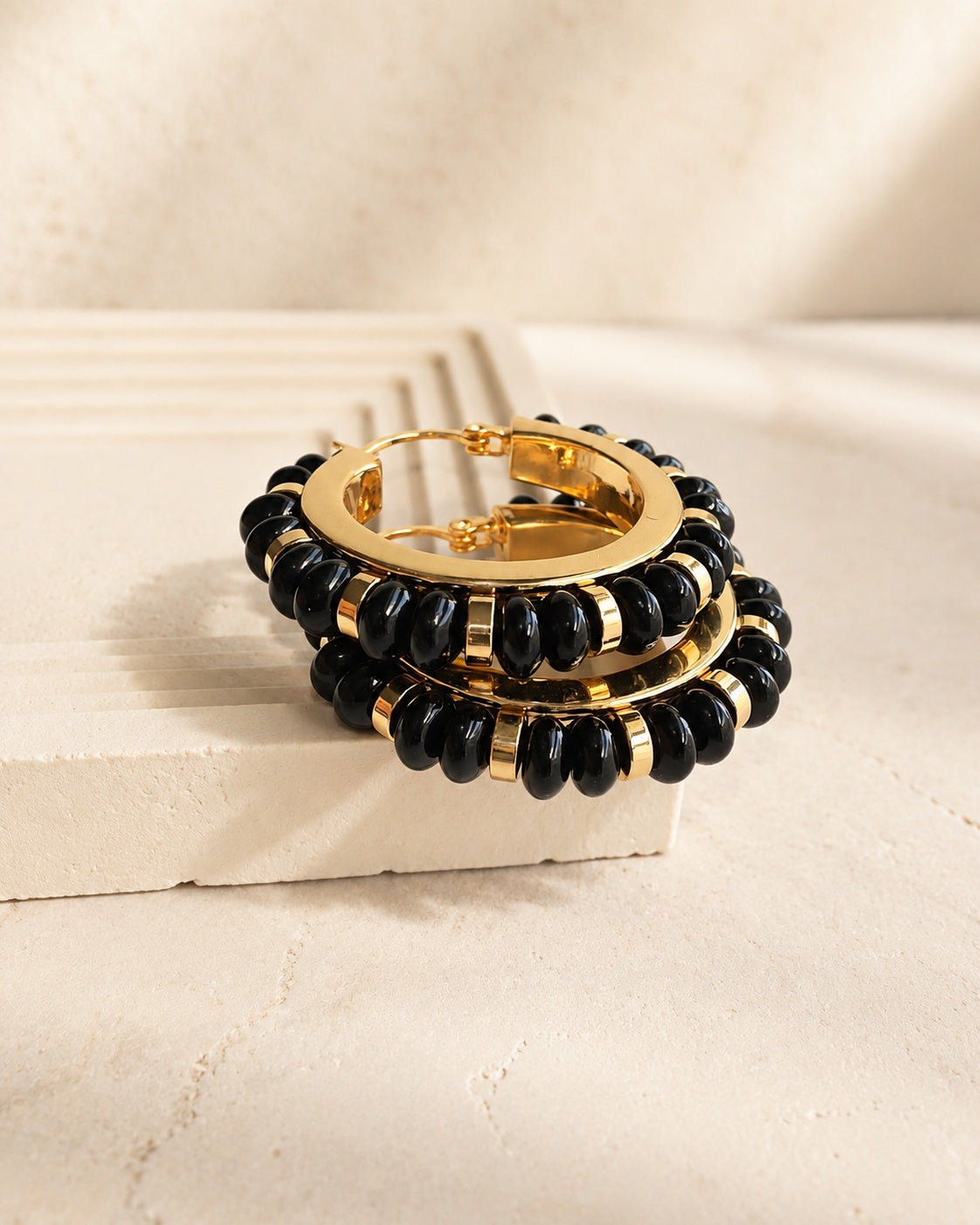 Women’s black onyx and gold hoop earrings