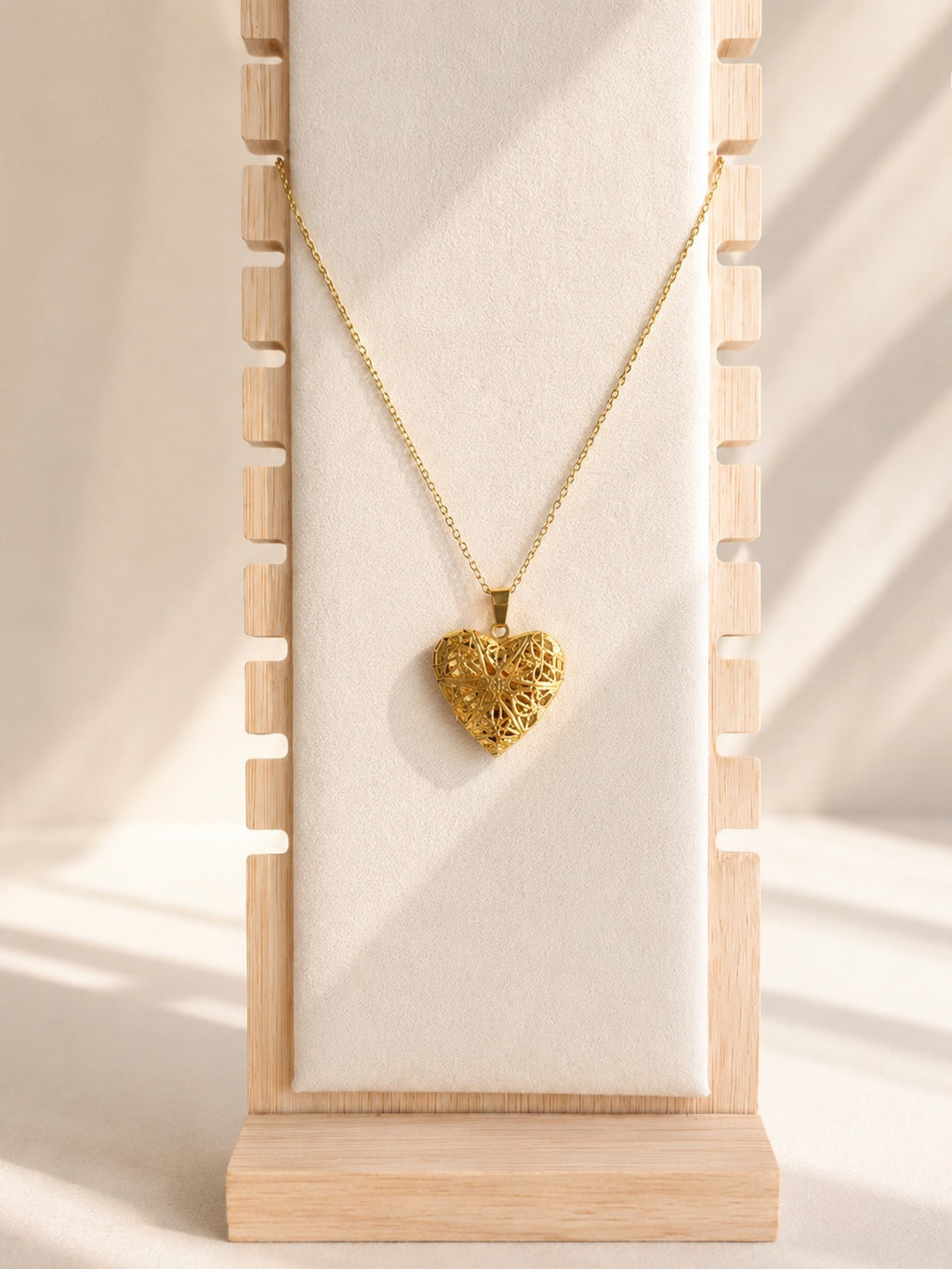 Silver heart locket necklace featuring a delicate filigree-style design.