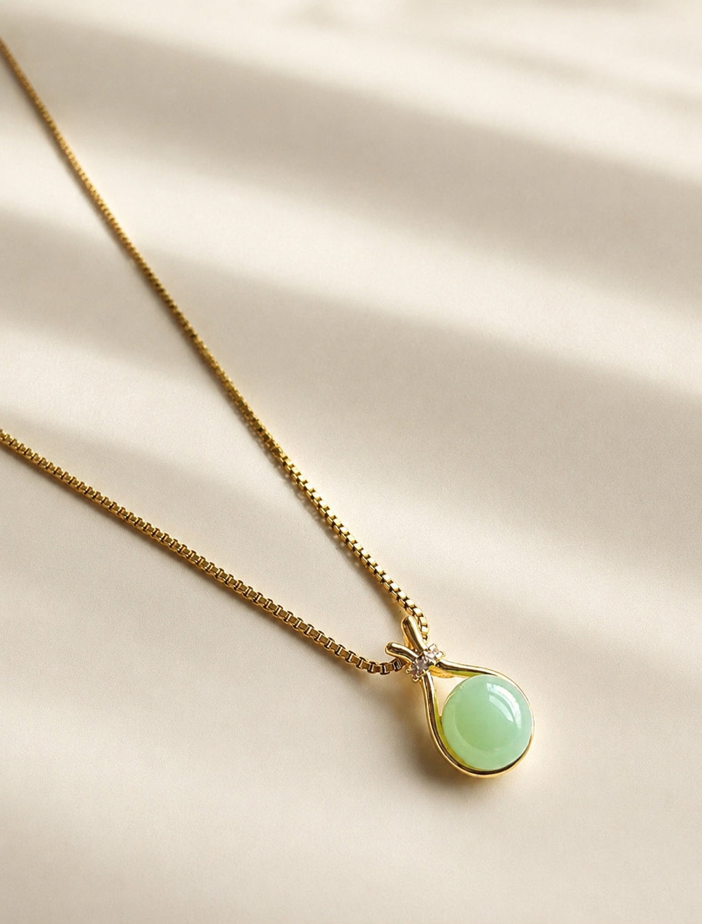 Green jade pendant necklace with a polished 14K gold-plated chain.
