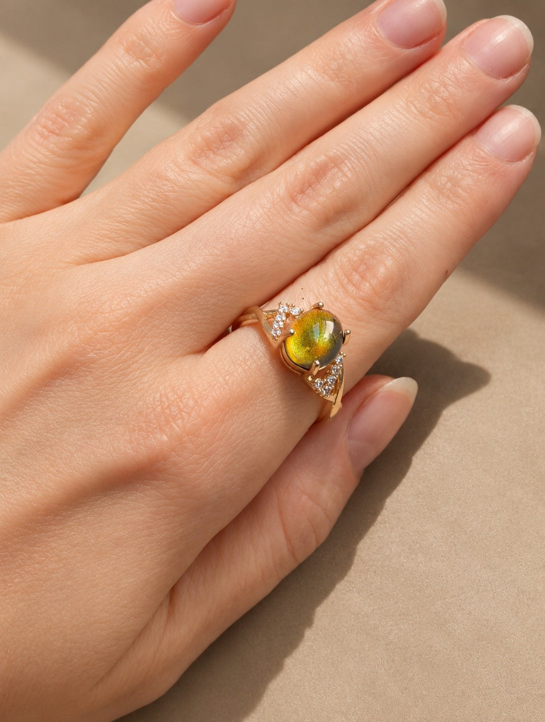Adjustable 14K gold-plated mood ring featuring a vibrant color-changing centerpiece.