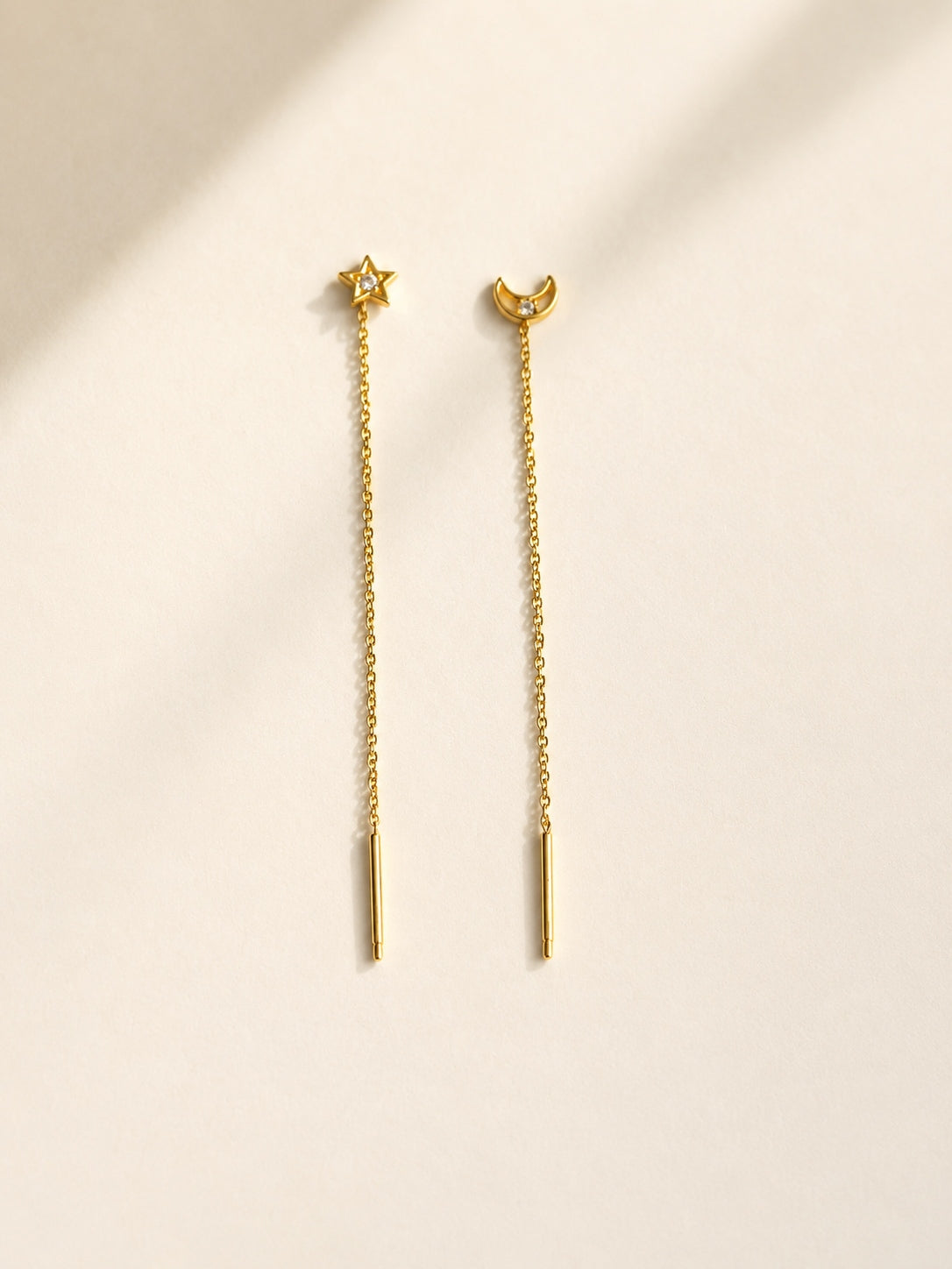 Silver celestial threader earrings featuring moon and star charms.