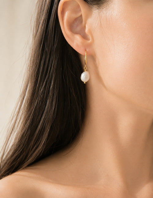 Natural baroque pearl hoop earrings with a polished non-tarnish gold finish.