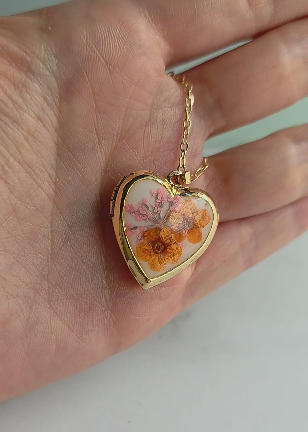 Heart locket necklace with genuine pressed flowers in 18K gold-plated and silver finishes, handcrafted for everyday wear and meaningful gifts.