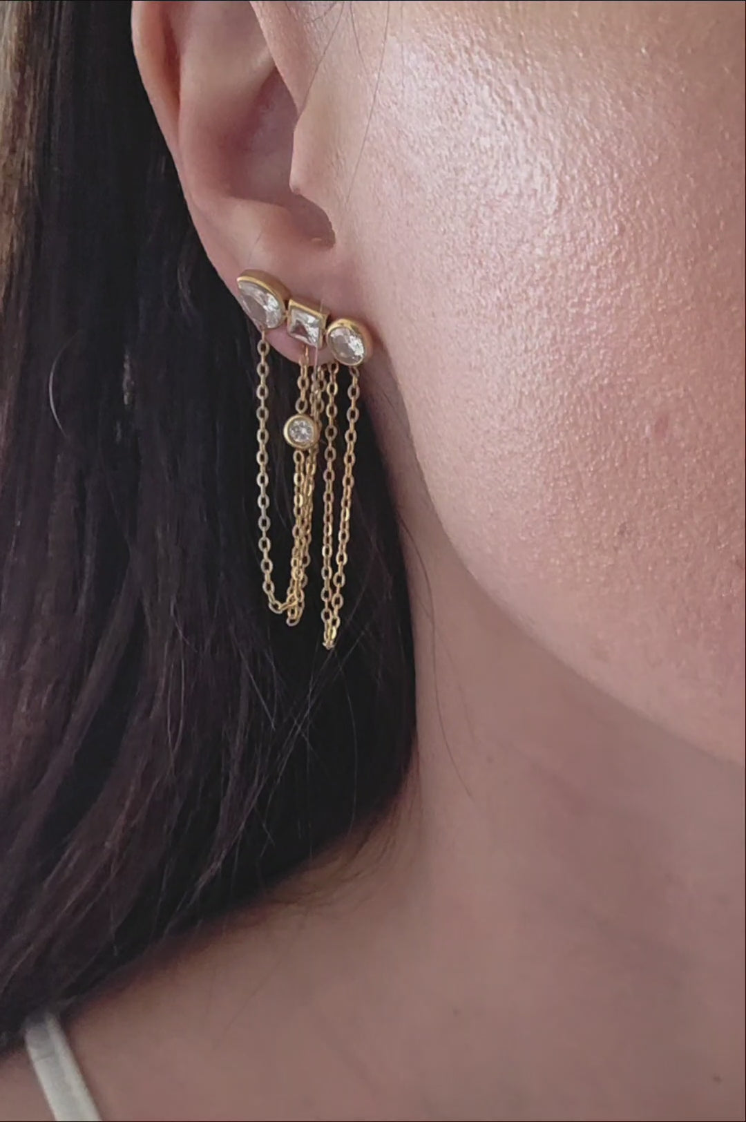 Gold geometric dangle earrings with sparkling CZ stones and delicate chain accents.