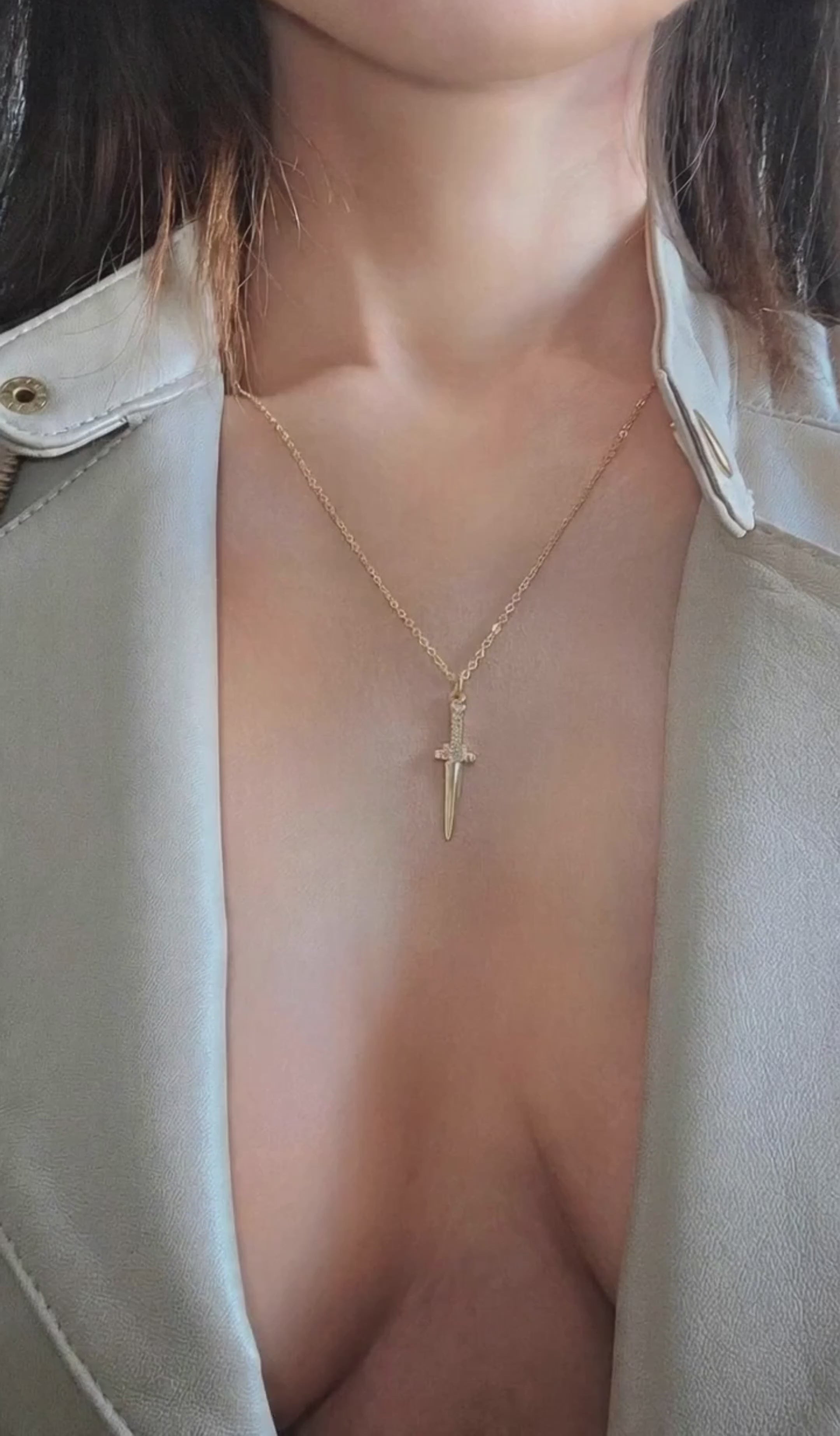 Gold sword pendant necklace with a sleek minimalist design and CZ stones.
