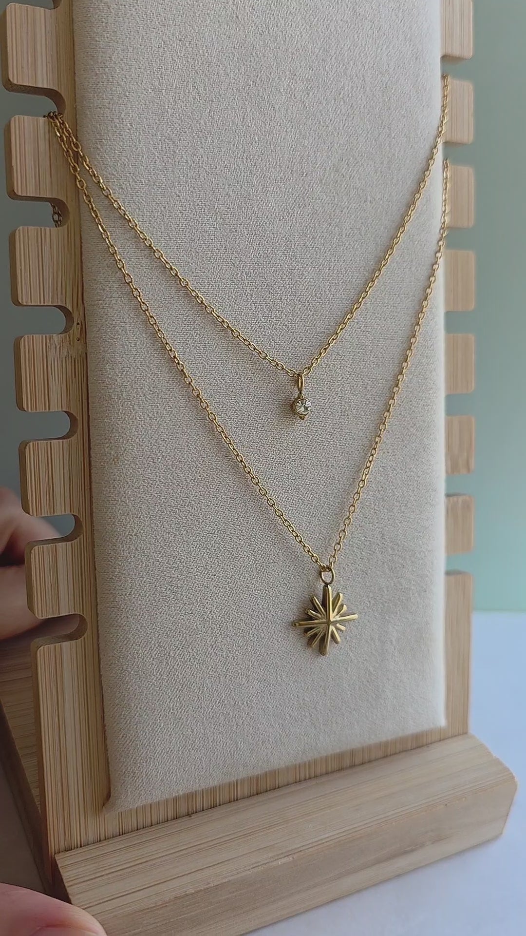 Gold North Star pendant necklace with opal detail.
