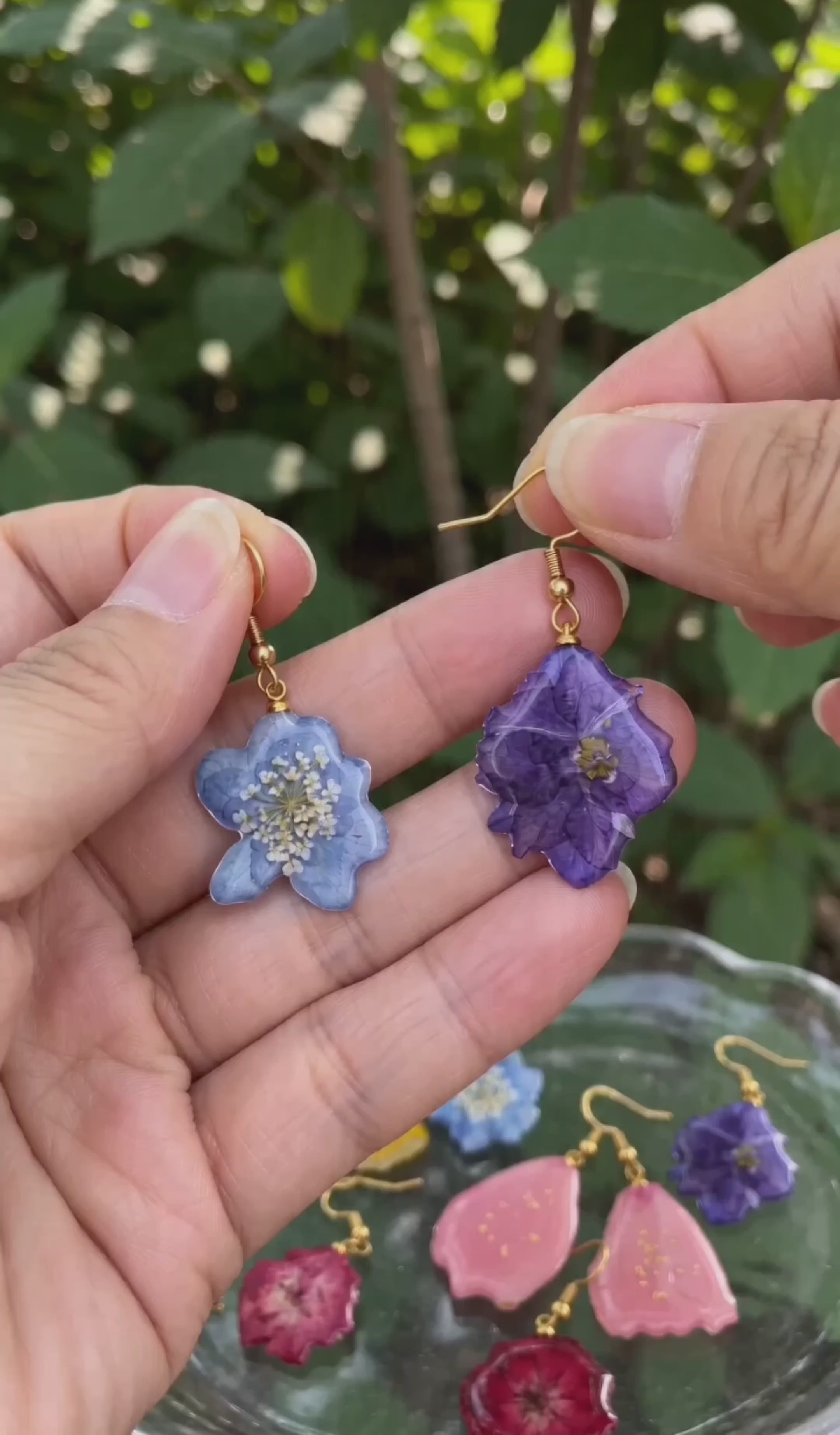 Real flower dangle earrings in colorful botanical designs.