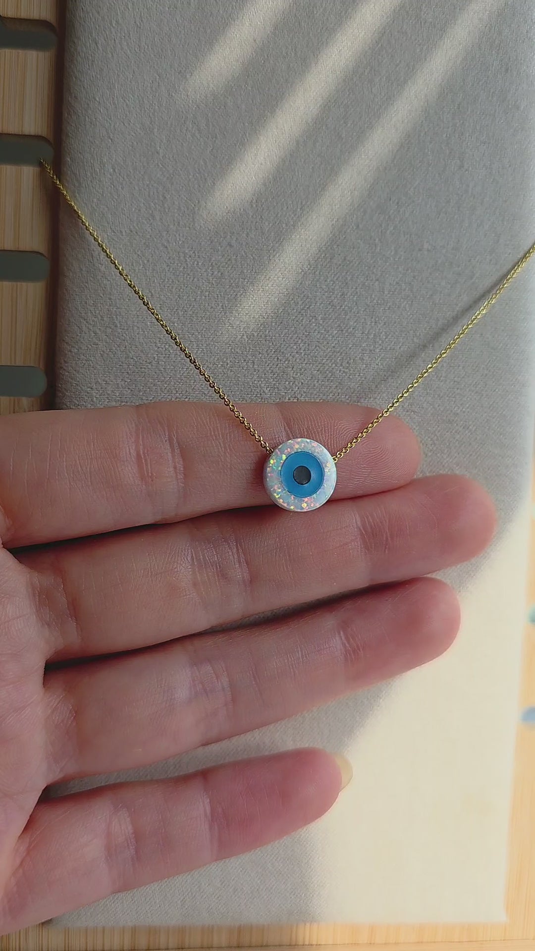Minimalist protection necklace with an evil eye opal charm.