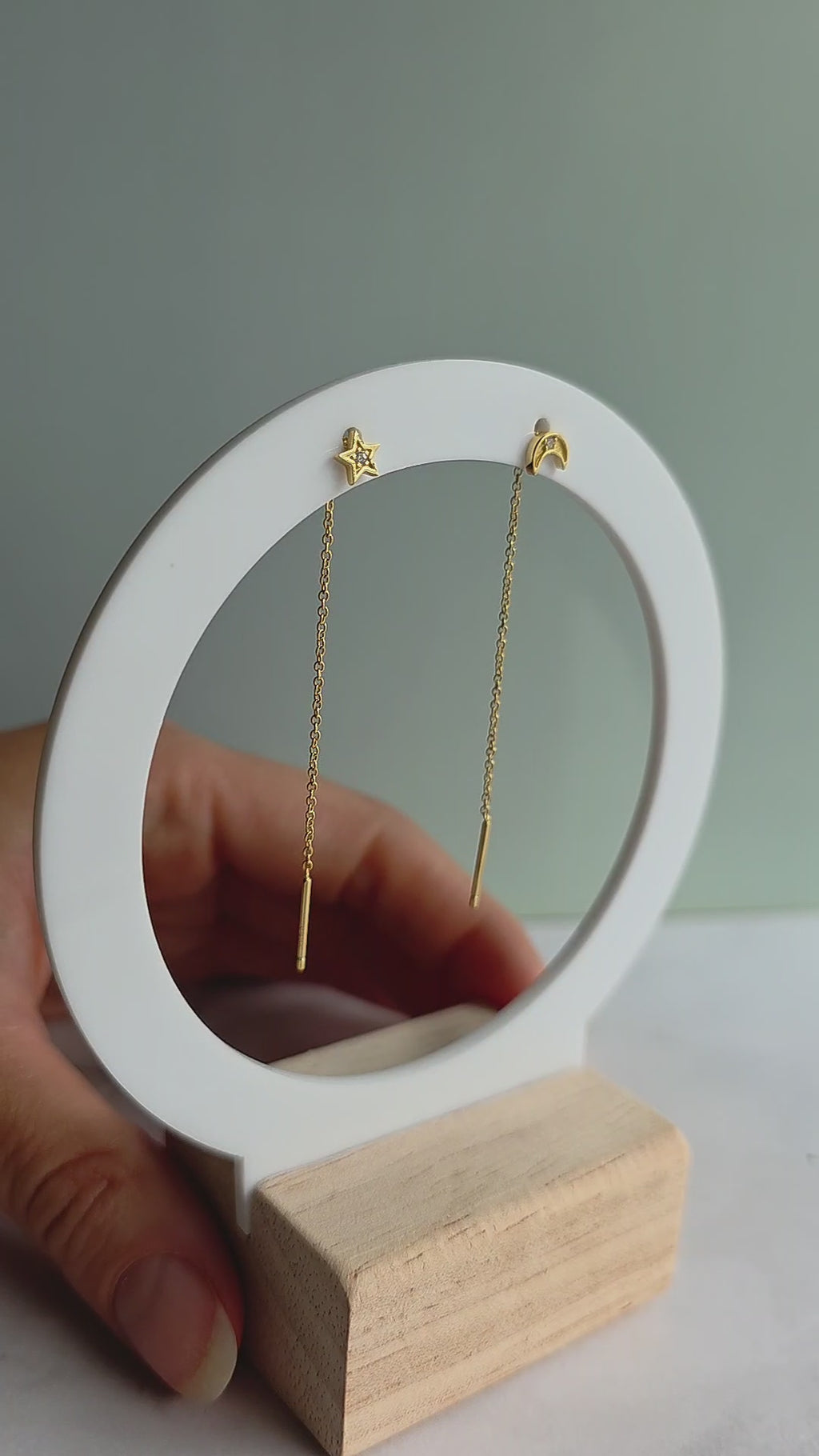 Gold threader earrings with moon and star design.