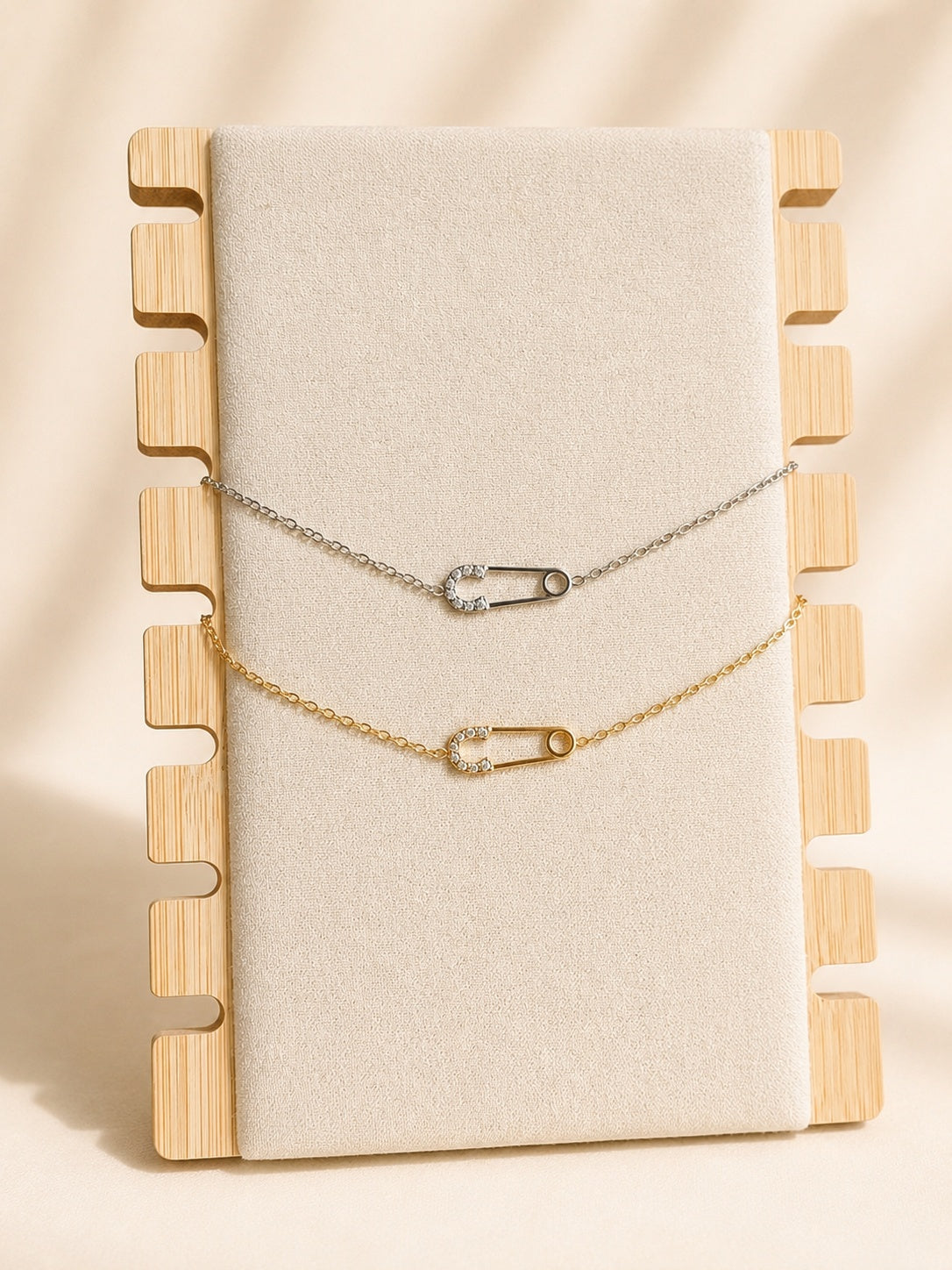 Safety pin necklace with an 18K gold-plated chain and sparkling CZ pendant.