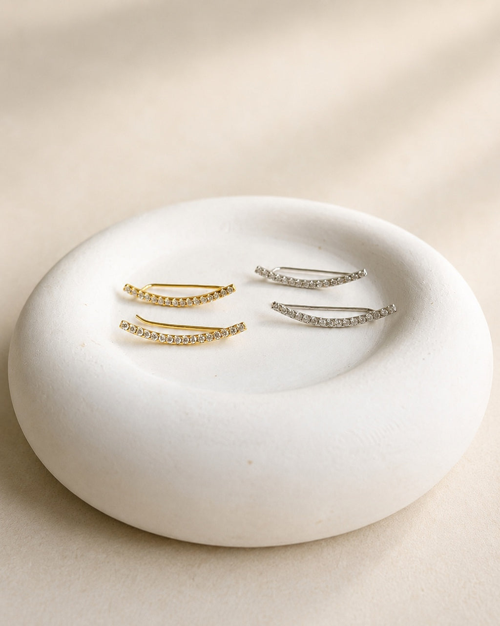 Silver ear crawler earrings with elegant curved design.