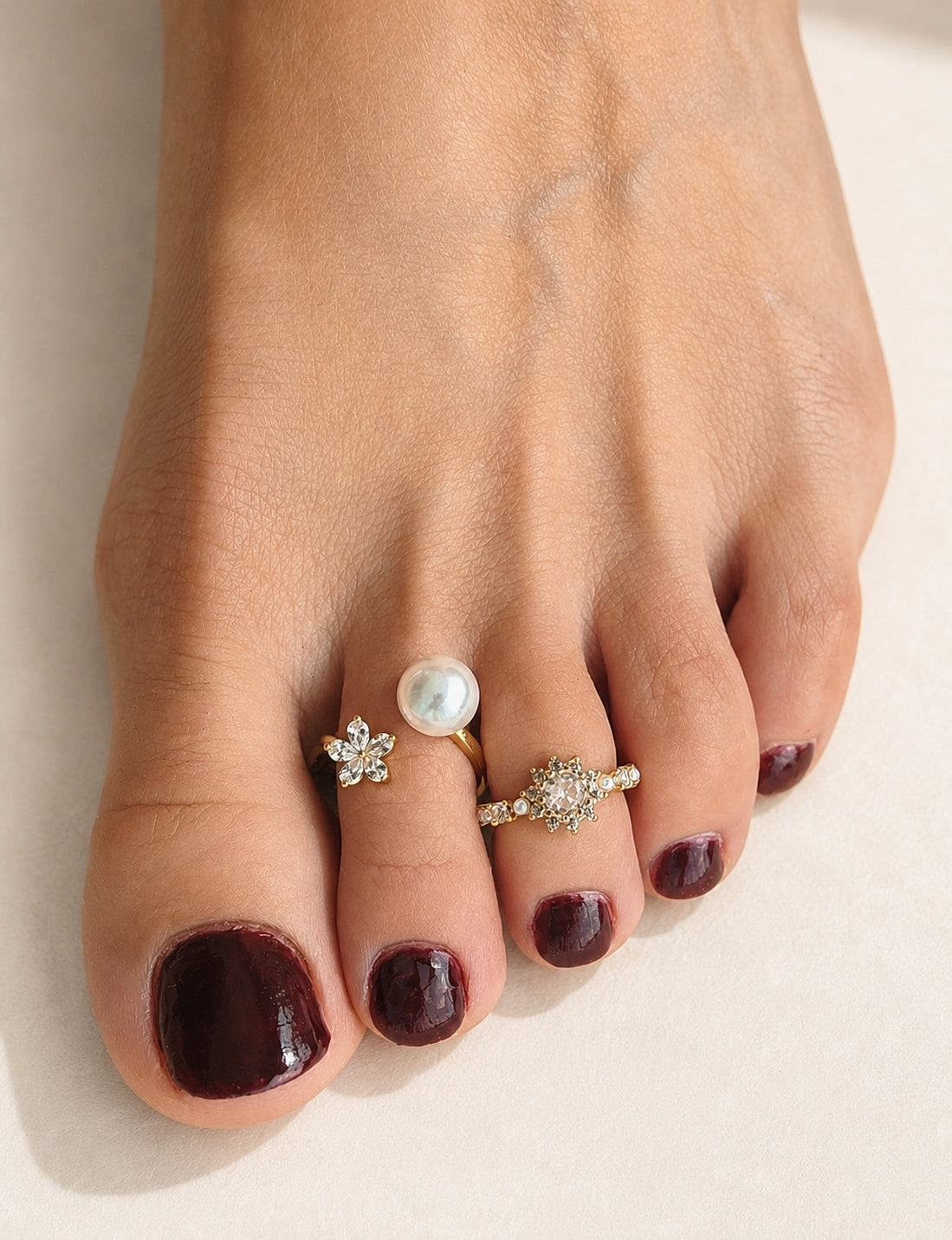 Waterproof gold toe ring set with CZ, pearl, and flower designs.