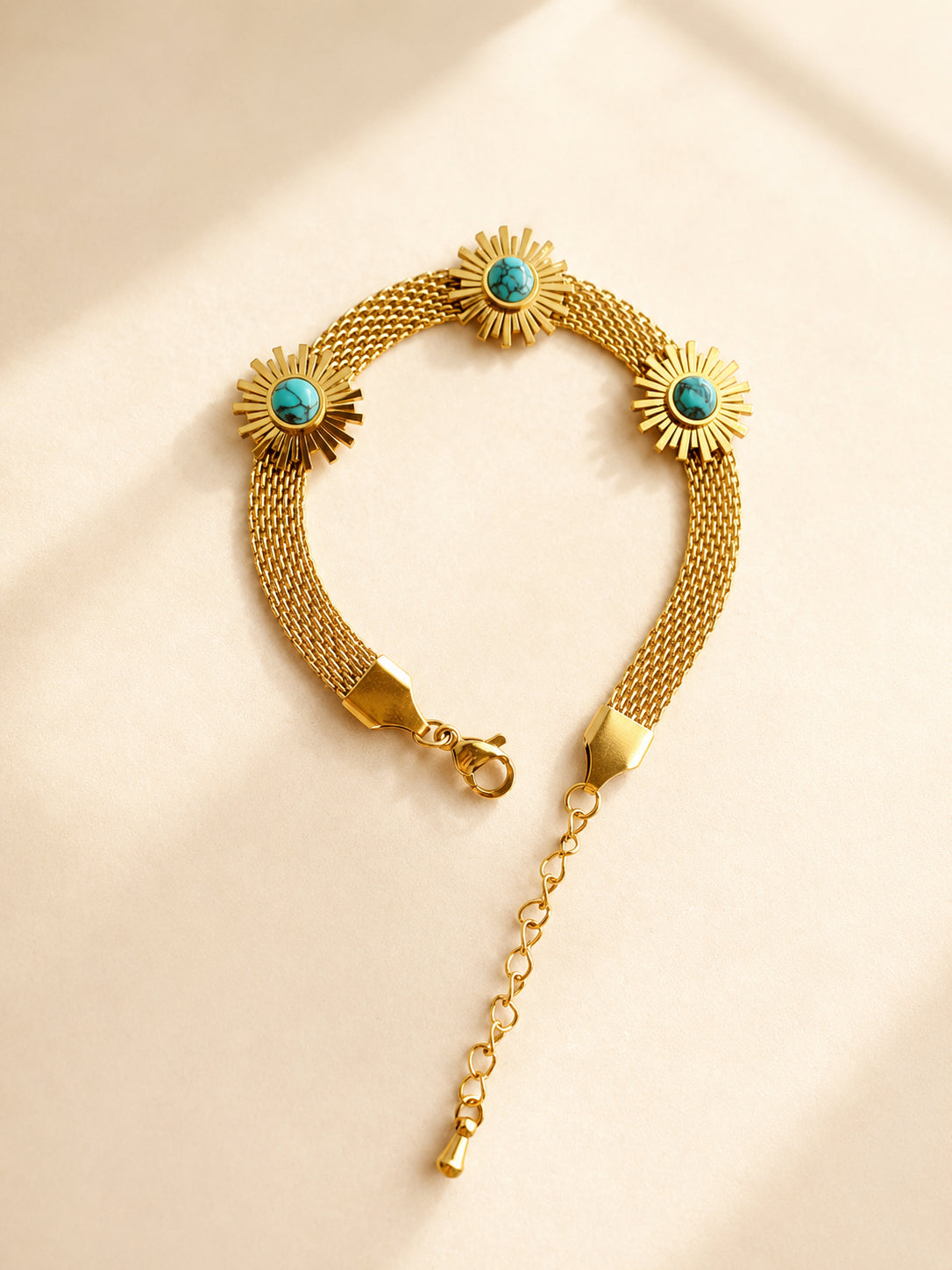 Boho sunflower bracelet featuring a turquoise-colored centerpiece and gold-plated mesh chain.